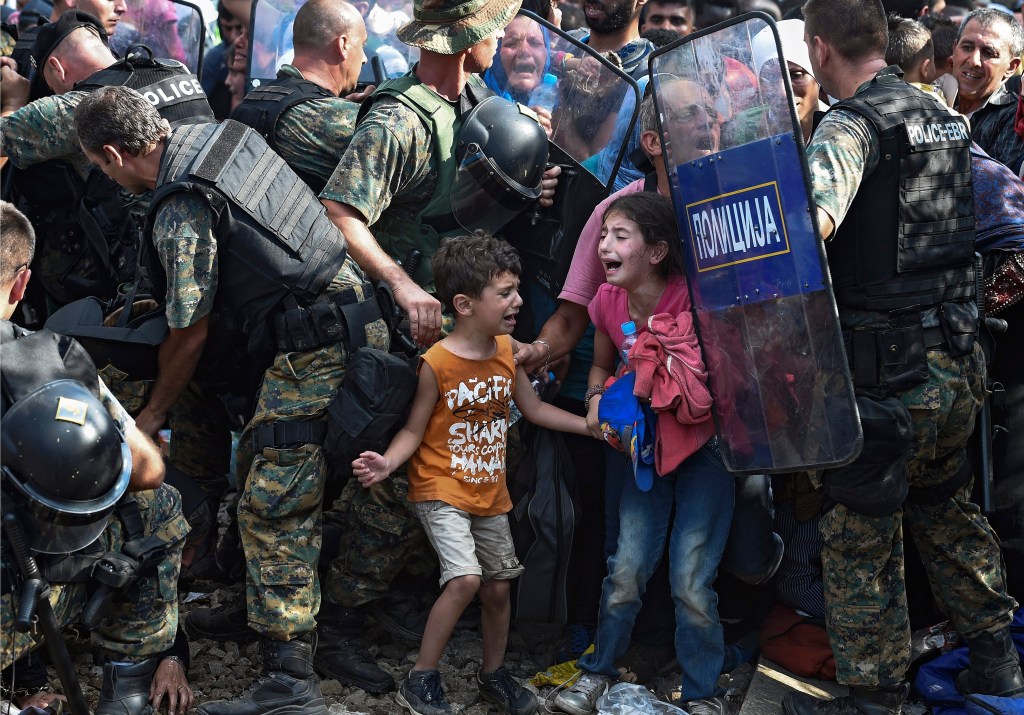 Children cry as migrants waiting on the Greek side of the border break through a cordon of Macedonian special police forces to cross into Macedonia, near the southern city of Gevgelija, The Former Yugoslav Republic of Macedonia, 21 August 2015. Macedonian police clashed with thousands of migrants attempting to break into the country after being stranded in no-man's land overnight, marking an escalation of the European refugee crisis for the Balkan country. EPA/GEORGI LICOVSKI